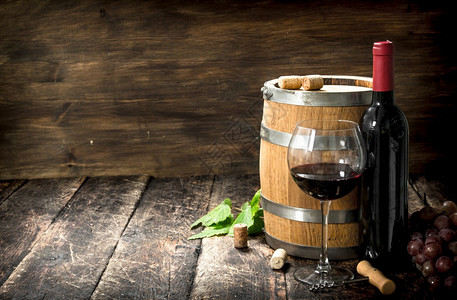 红酒桶里有葡萄和木本底的瓶装酒红桶里有葡萄和瓶装酒背景图片