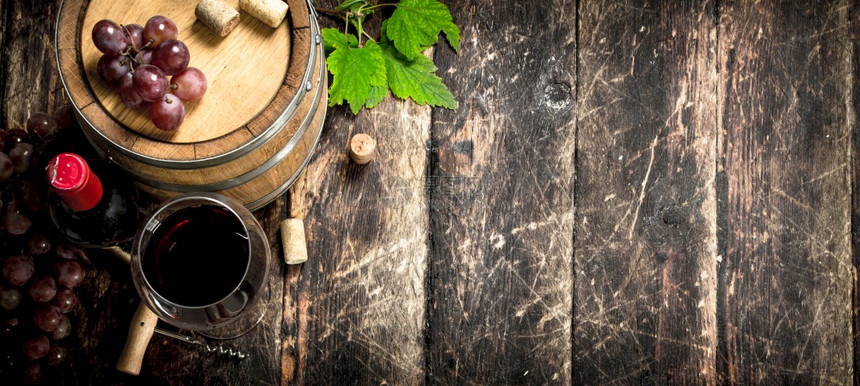红酒桶里有葡萄和木本底的瓶装酒红桶里有葡萄和瓶装酒图片