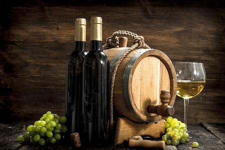 白葡萄酒背景一桶白葡萄酒配有绿枝子木制背景红酒配有绿葡萄枝子背景图片