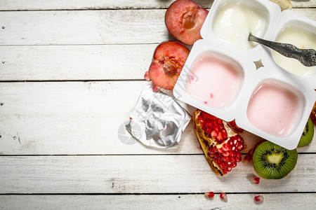 各种水果酸奶放在白木桌上图片