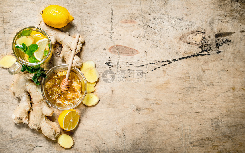 含薄荷和柠檬的姜茶木制背景图片
