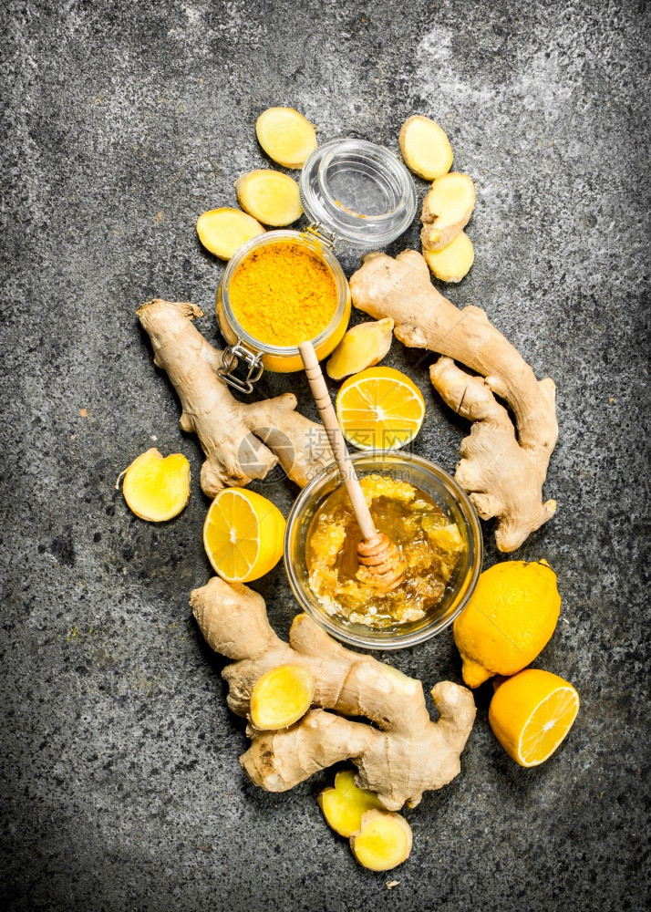 新鲜姜汁加蜂蜜和柠檬片生锈背景图片