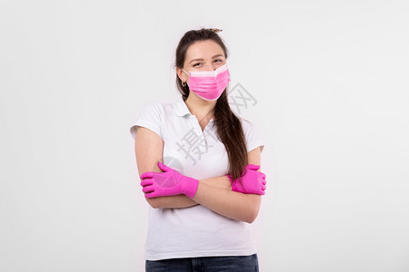 白底带粉红色医疗面具的美女身戴医疗面具的妇女防流感的护措施家中戴保护面罩的耳朵停止冠状白底带粉色医疗面具的美女戴医疗面具的女子防背景图片