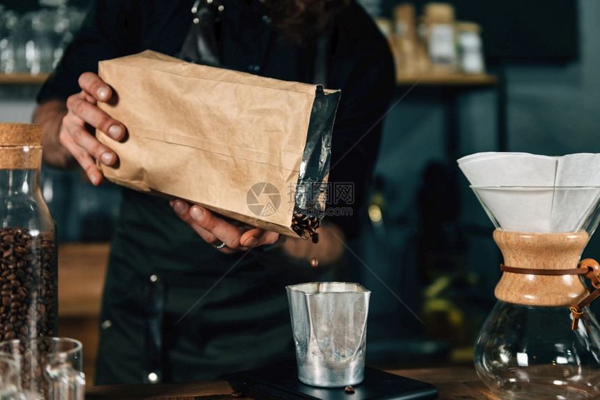 在咖啡店里用数字衡量咖啡身穿黑制服的纹手臂咖啡师图片