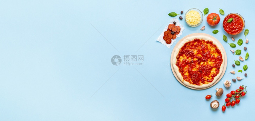 番茄酱在披萨面团上传播经典比萨饼土生长配有新鲜机成分图片
