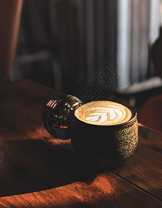 火热的拿铁咖啡在木制桌上的杯子热拿铁咖啡在木制桌上的杯子图片