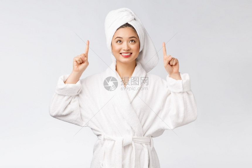 年轻女子穿着浴袍指向浴帽图片