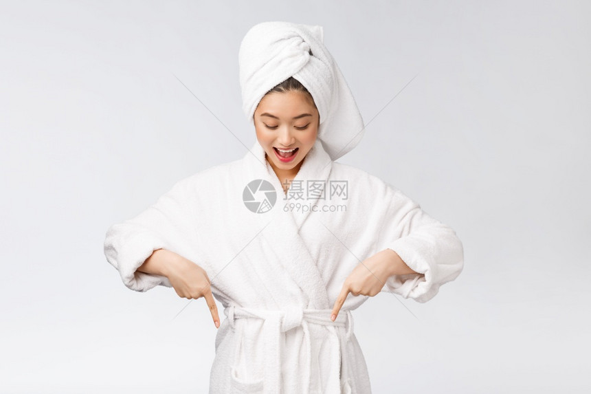 年轻女子指着浴袍微笑图片