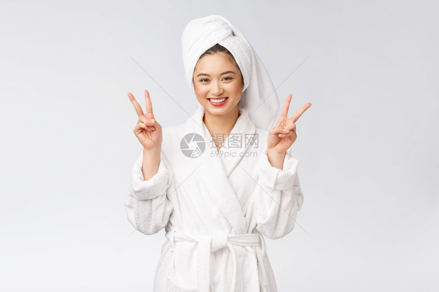 美丽的亚洲女人展示和平迹象或两只手指带着快乐的感觉被白种背景隔开图片