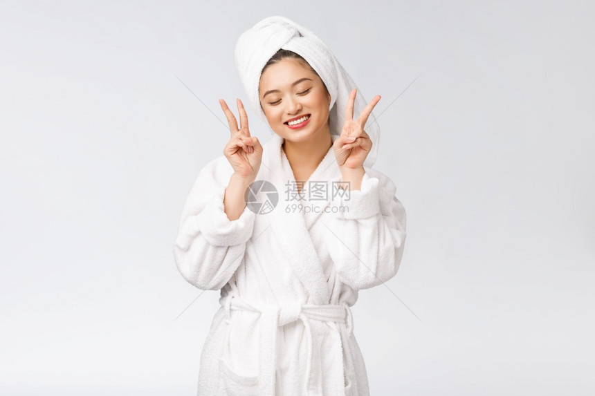 美丽的亚洲女人展示和平迹象或两只手指带着快乐的感觉被白种背景隔开图片