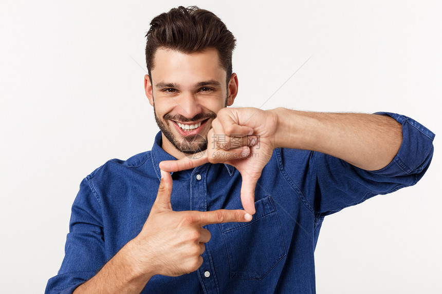 一位年轻的商人用手指画出一个框架然后微笑在镜头上白色一位年轻的商人用手指画出一个框架在白色上图片