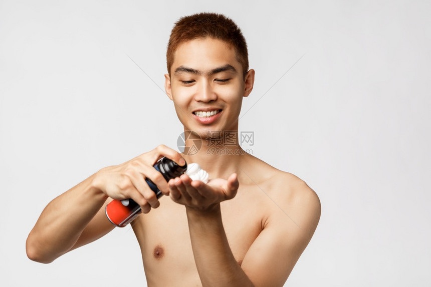 美貌人与卫生概念英俊的亚洲男子肖像他们赤裸的躯体站在浴室里并使用剃须霜手头喷洒泡沫微笑的喜悦白色背景美貌人与卫生概念英俊的亚洲男图片