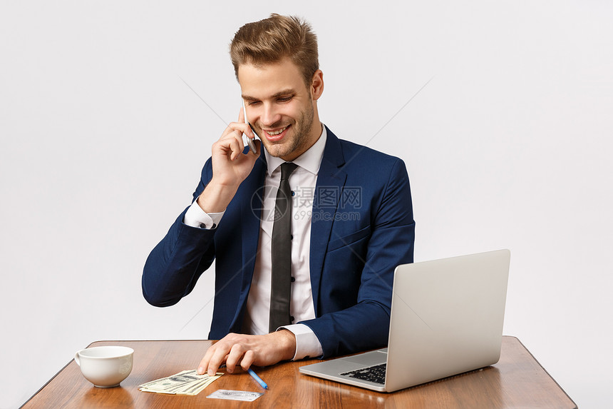 拥有无忧虑的年轻人坐在笔记本电脑旁边喝咖啡与在线商店经理交谈确保秩序正常持有智能耳朵白色背景图片