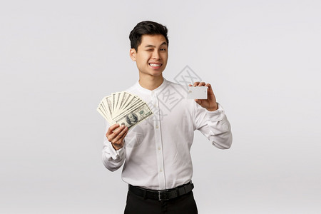 放松的银行快乐成功亚洲商人眨眼相机微笑的成功年轻商人微笑相机图片