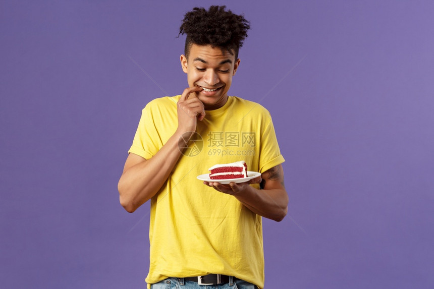 紫色背景下男青年手上拿着蛋糕图片