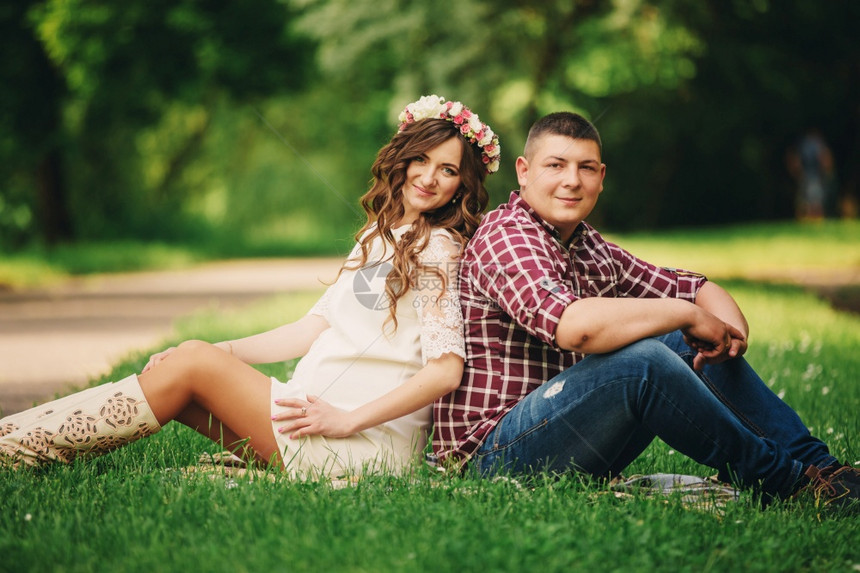 孕妇和丈夫在公园草地上图片