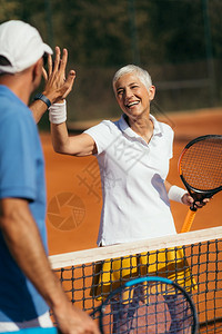 网球教练在户外和女子一起练球击掌背景图片
