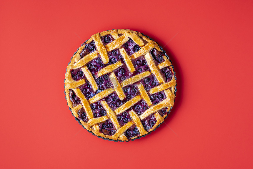 蓝莓馅饼夹着薄壳放在红色无缝背景的盘子上经典水果馅饼的顶层视图从头到尾的蓝莓薄饼name图片