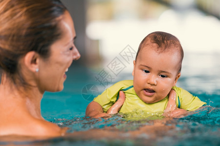 在游泳池中母亲和婴儿图片