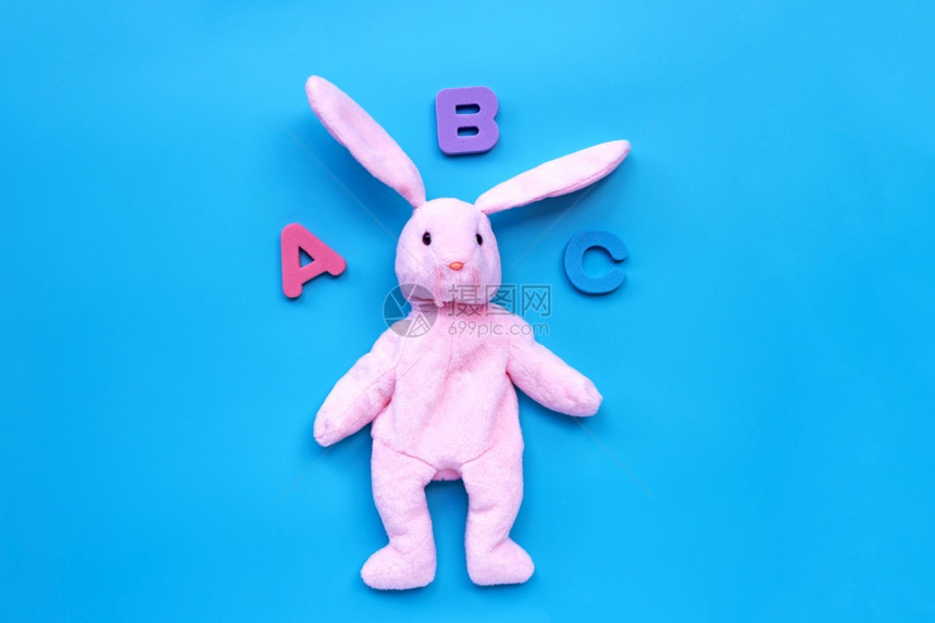 蓝背景的兔子玩具有英文字母教育概念复制空间图片