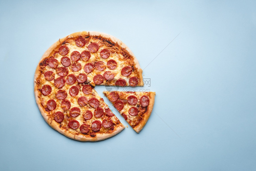 蓝色背景的薄荷披萨传统的意大利菜带家用烤披萨的平板热辣椒和莫扎里拉图片
