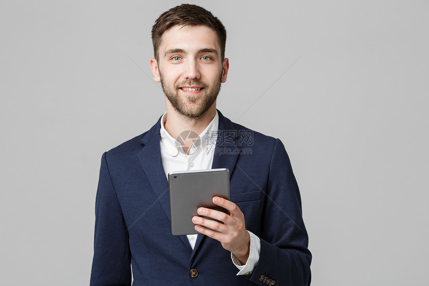 商业概念肖像英俊的商人玩数字平板电脑微笑自信的脸白色背景复制空间图片