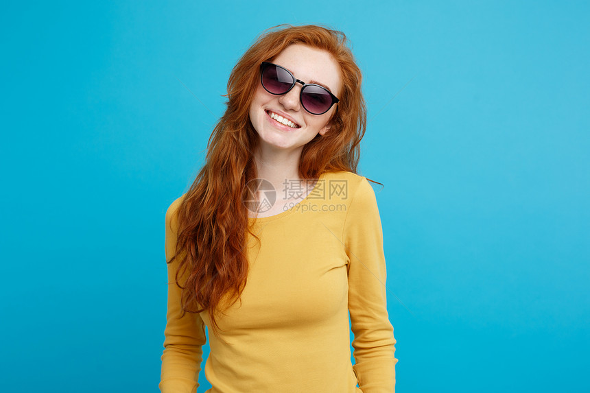 旅行概念关闭肖像年轻美丽的迷人姜红发女孩时髦的太阳镜微笑蓝色的面部背景复制空间图片