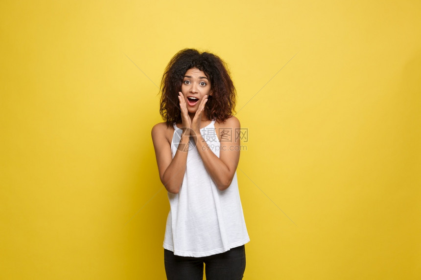 身着白色t恤的美丽非洲年轻女手放在下巴上工作室拍摄的是黄色背景复制空间身着白色t恤手放在下巴上笑着美丽的非洲年轻女复制空间图片