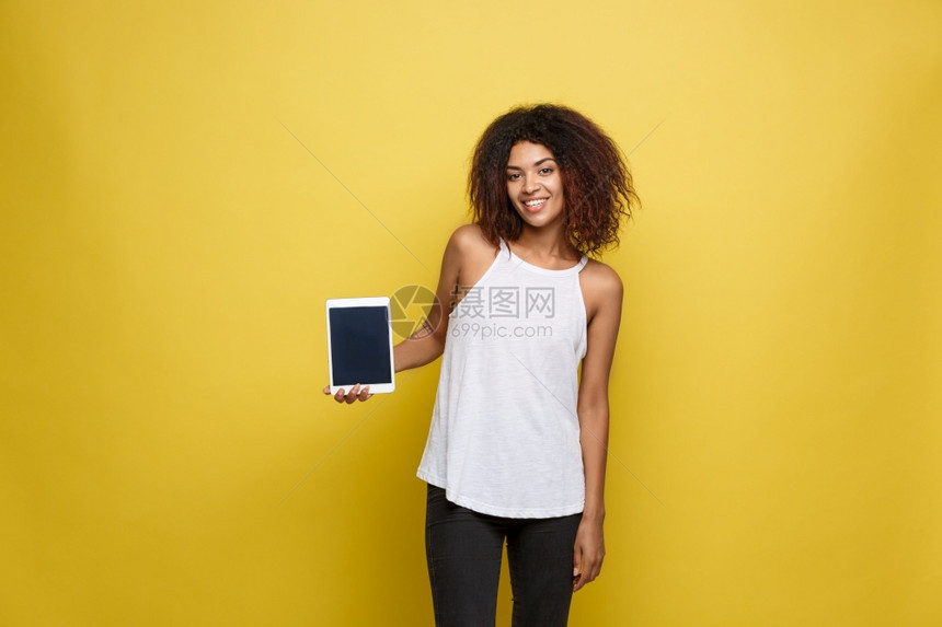 美籍女在电子平板黄色面片工作室背景上展示快乐的东西复制空间生活方式概念图片