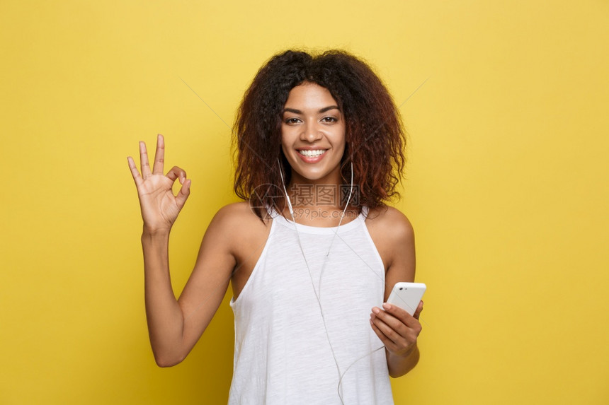 非洲的pofesinalprfesin美丽的籍女在手机上欢乐地聆听音并用手指显示好牌黄色的糊面工作室背景复制空间生活方式概念美丽图片
