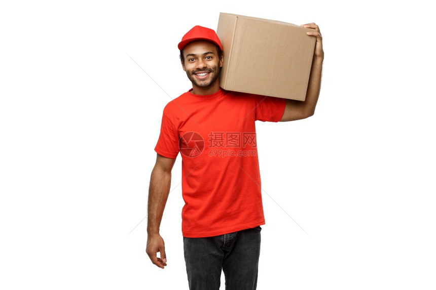 交付概念身着红布的非洲快乐送货员的肖像身着一盒子孤立在白色工作室背景上复制空间身着一盒子的非洲快乐送货员的红布肖像身着白色工作室图片