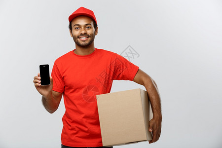 英俊的非洲送货员或快递的肖像显示您检查订单的手机盒孤立在灰色工作室背景上复制空间交付概念复制空间背景图片