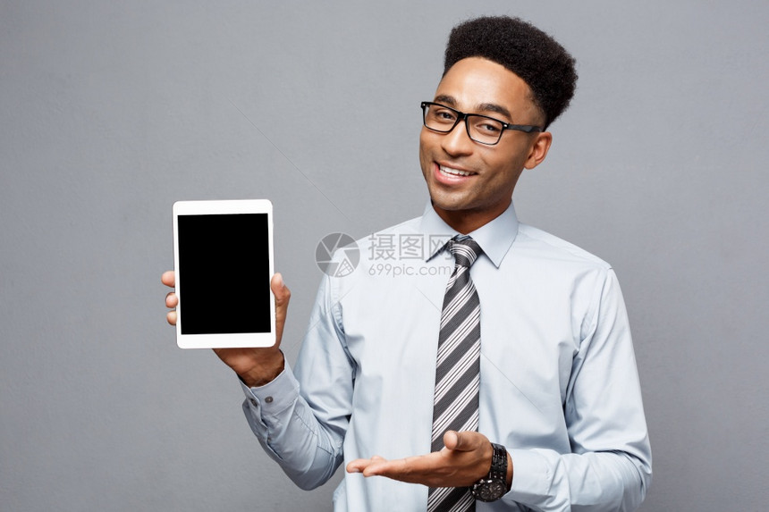 商业概念快乐英俊的非洲专业商人向客户展示数字平板电脑图片
