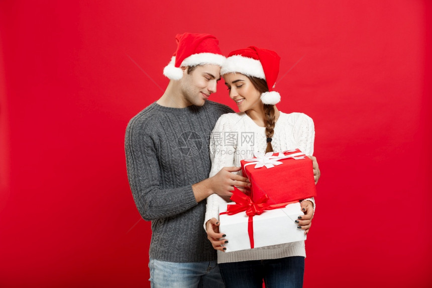 圣诞节概念圣诞节毛衣中英俊的年轻男友给他女朋带来礼物给他的女朋友带来惊喜圣诞节毛衣中英俊的年轻男友给他女朋带来礼物图片