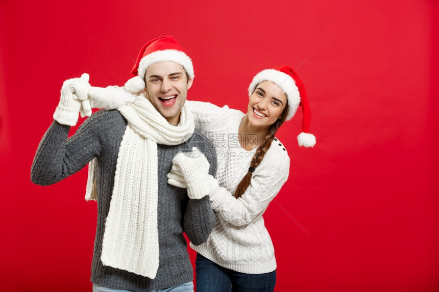 圣诞节概念圣诞快乐的一对年轻夫妇以玩和跳舞庆祝圣诞节快乐的一对年轻夫妇以玩和跳舞庆祝圣诞节图片
