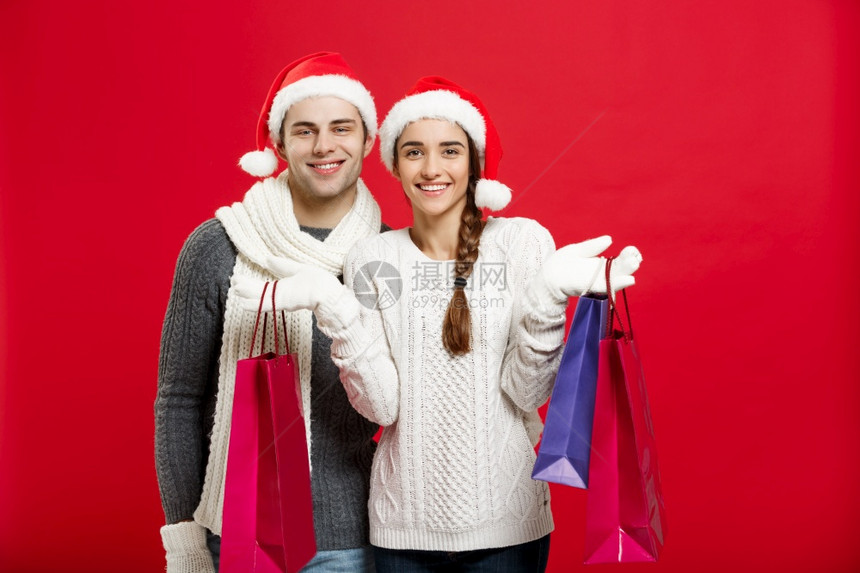 圣诞节概念持有购物袋的年轻吸引力夫妇享受购物和庆祝圣诞节持有购物袋的年轻吸引力夫妇享受购物和庆祝圣诞节图片