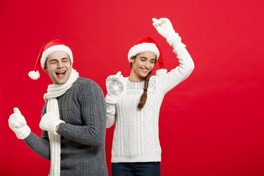 圣诞节概念圣诞快乐的一对年轻夫妇以玩和跳舞庆祝圣诞节快乐的一对年轻夫妇以玩和跳舞庆祝圣诞节图片