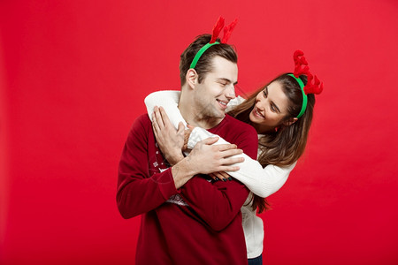 穿着圣诞毛衣的情侣相互拥抱背景图片