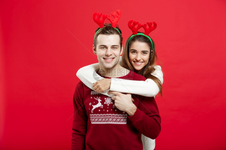 穿着圣诞毛衣的情侣相互拥抱图片