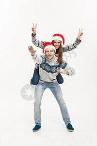 男子戴着圣诞帽背着女友玩耍图片
