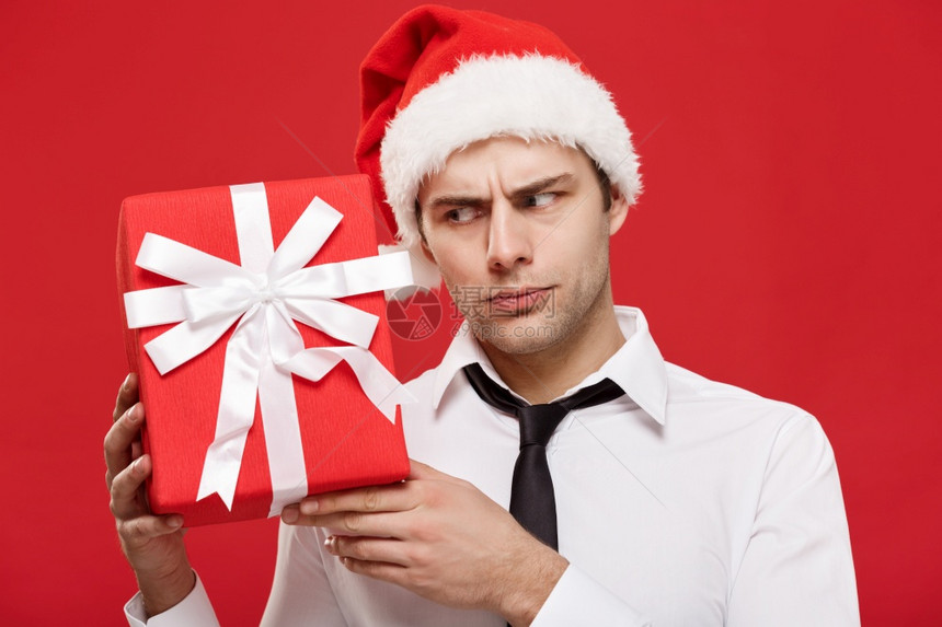 圣诞概念肖像近身圣誕商人在红色背景持有礼图片