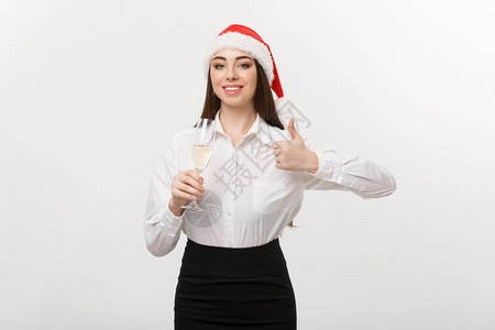 圣诞庆典年轻美丽的商业女人庆祝圣诞节喝着香槟露出拇指图片