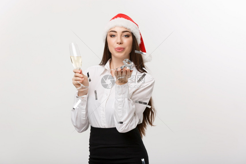 圣诞节的概念年轻商业妇女拿着香槟和吹彩蛋白图片