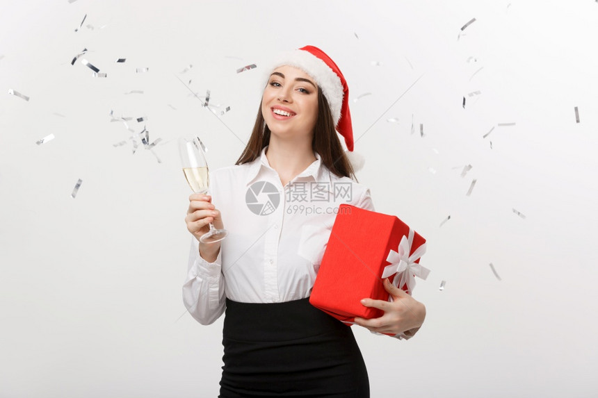 圣诞节概念年轻女商人拿着香槟带彩色背景图片