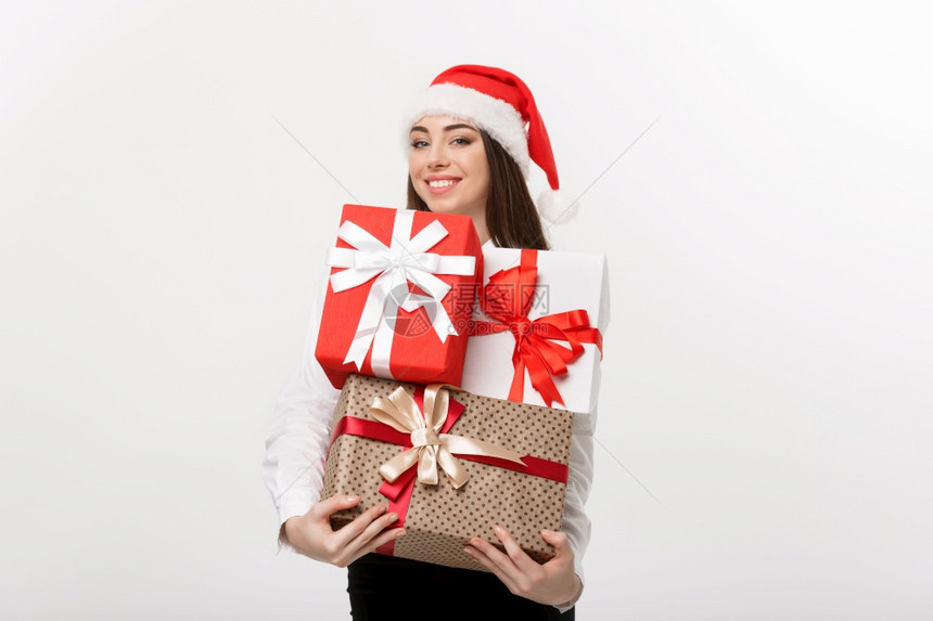 商业概念美丽的天主教女商人戴着圣诞帽拿许多圣诞礼物盒上面有复制空间商业概念漂亮的天主教女商人上面有圣诞女商人上面有很多装饰空间的图片