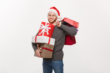 圣诞概念长胡子的帅小伙拿着很多礼物和购袋图片