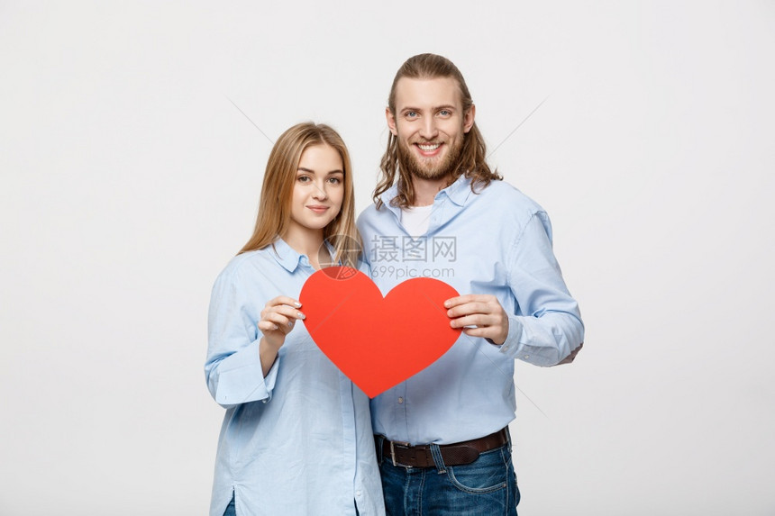 年轻快乐的情侣一起拿着一个大红心图片