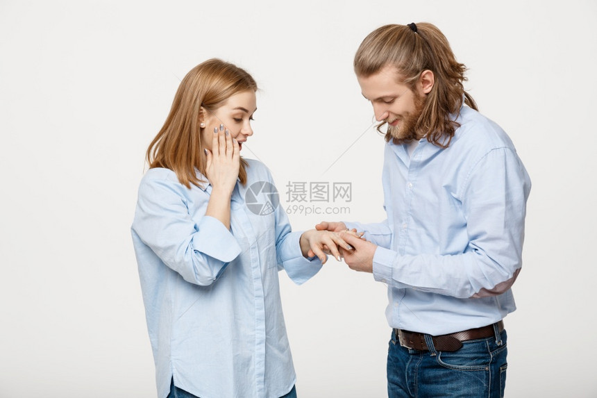 快乐的英俊男人肖像穿着订婚戒指为她的女朋友在孤立的白色背景上快乐的英俊男人肖像穿着订婚戒指为她的女朋友在孤立的白色背景上图片