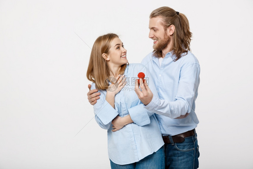 提议概念男人的肖像显示订婚戒指钻石给他的漂亮女友超过孤立的白色背景显示订婚戒指钻石给他可爱的女朋友图片