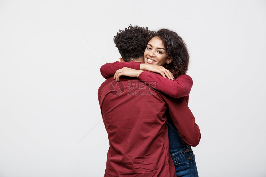 快乐的非洲夫妇在白色背景中拥抱对方图片